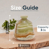 Green glass bottle with measurements and capacity details on a wooden surface