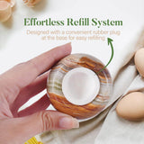 Hand holding a decorative shell with an effortless refill system label