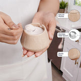 Person holding a small beige bowl with a spoon, showing natural marble, stainless steel spoon, and sturdy base features.