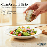 A hand holds a marbled condiment dispenser over a salad bowl on a kitchen counter