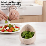 Marble herb peeler with herbs next to a salad on a kitchen counter.